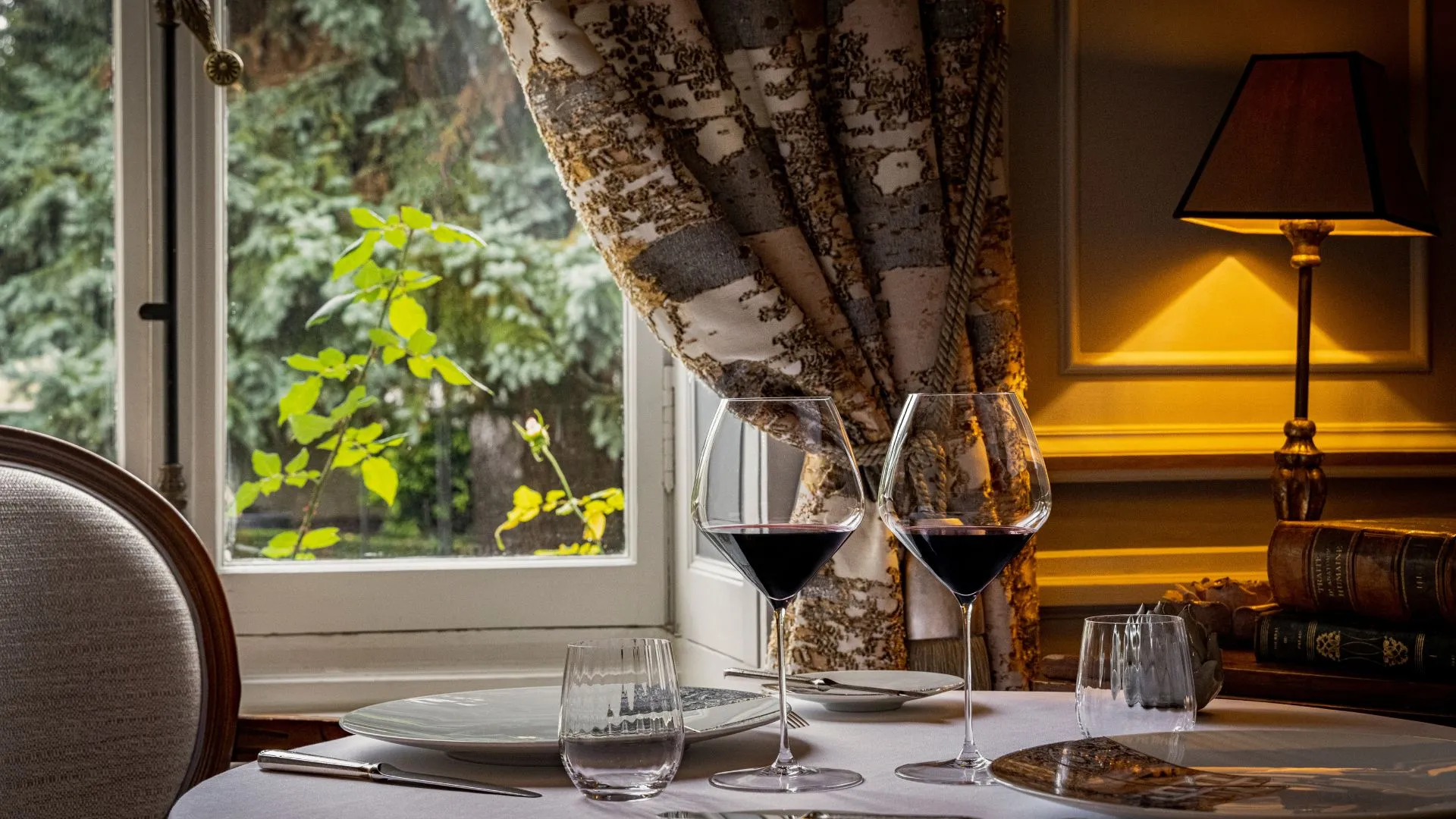 Gedeckter Tisch mit Weingläsern im Gourmetrestaurant der Hostellerie Cèdre & Spa in Beaune im Burgund.
