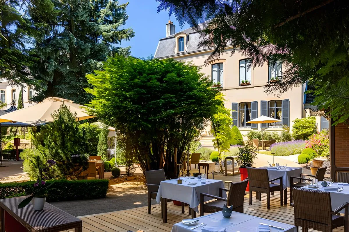 Terrazza del ristorante gastronomico Le Clos du Cèdre a Beaune, nei giardini dell'Hostellerie Cèdre & Spa in Borgogna.