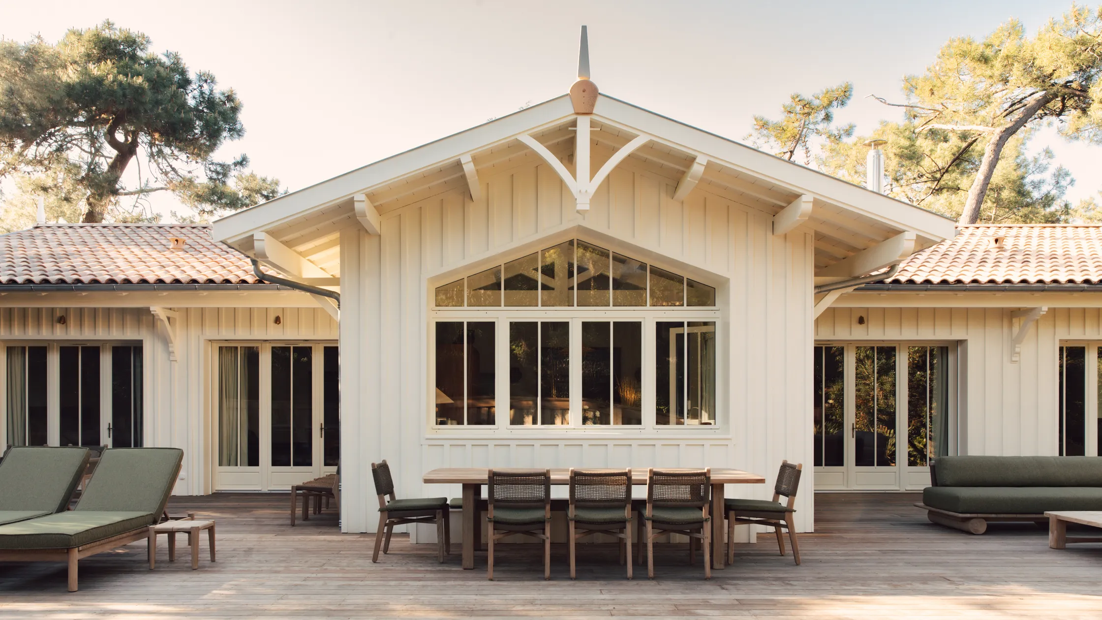 Moderne Holzvilla mit Terrasse und Pool, integriert in eine natürliche Umgebung.