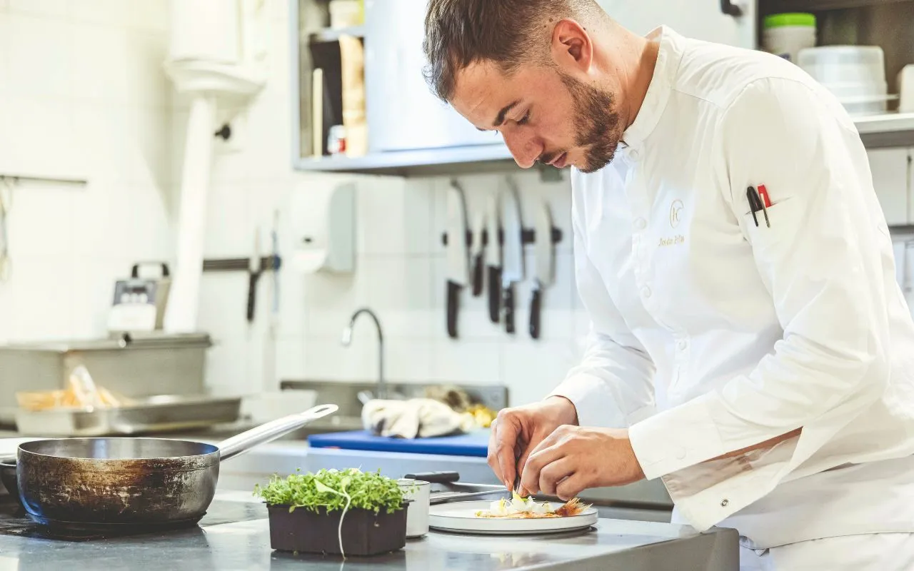 Chef preparing a gourmet plate in the kitchen.