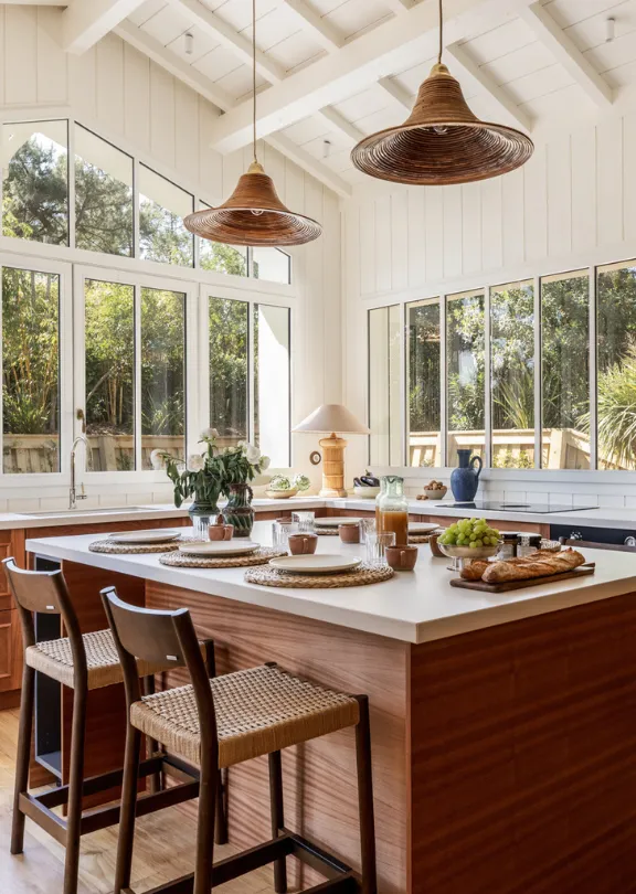 Cucina aperta e luminosa della Maison Oyat a Cap Ferret con isola centrale e grandi vetrate.