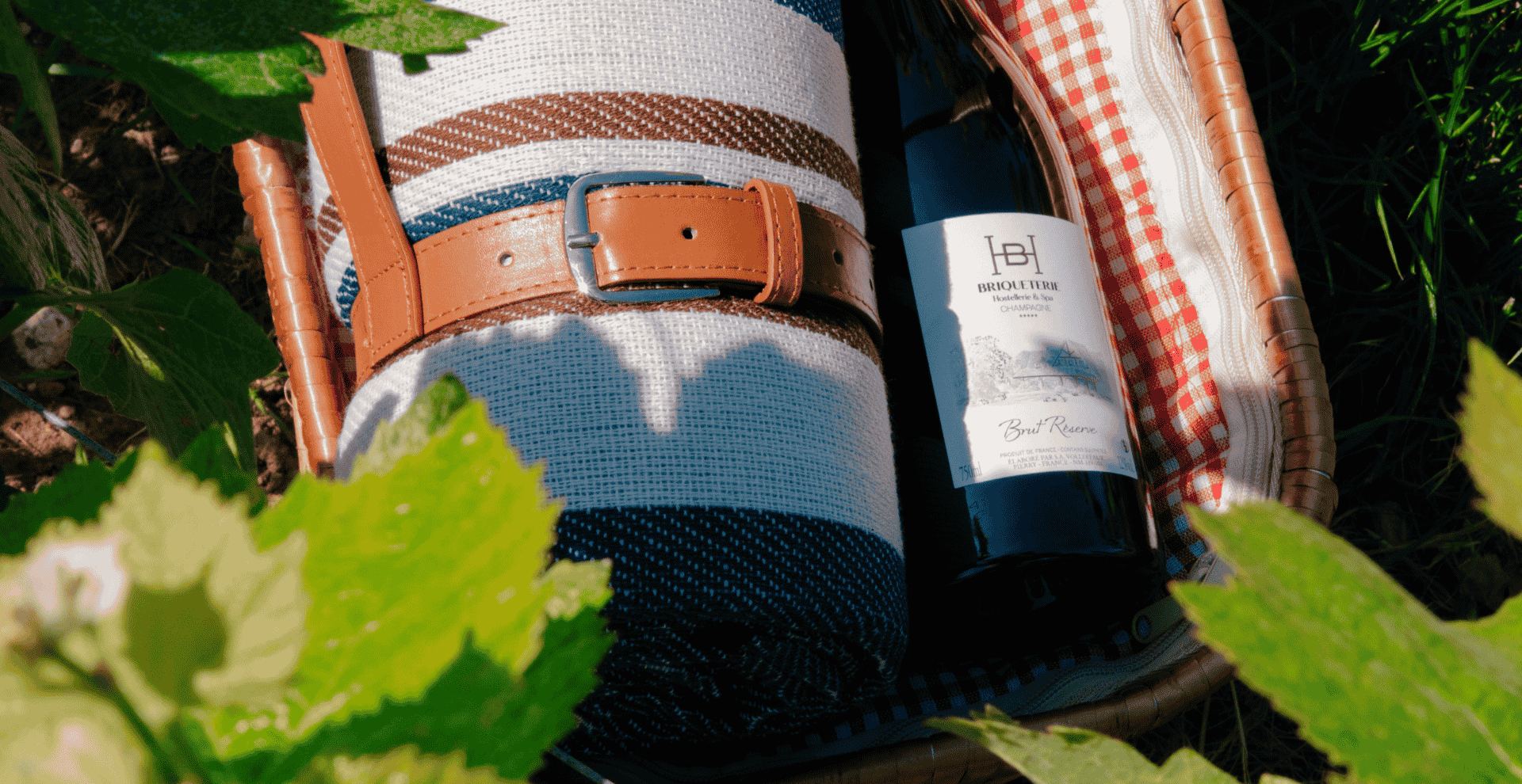 Picnic basket with champagne and blanket for a gourmet experience offered by the Hostellerie Briqueterie & Spa.