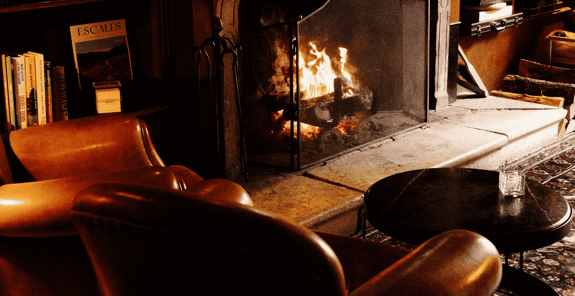 Warme Lounge mit Kamin und Ledersesseln in der Hostellerie Cèdre & Spa