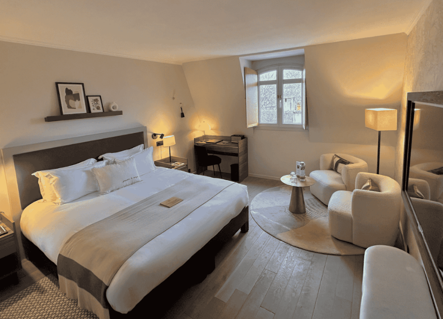 Suite Cedar Signature con cama doble y sala de estar en la Hostellerie Cèdre & Spa de Beaune.