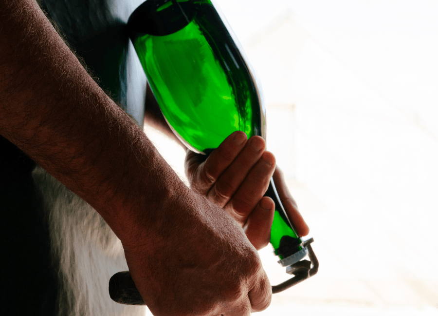 Opening a bottle of champagne by hand in a wine estate.
