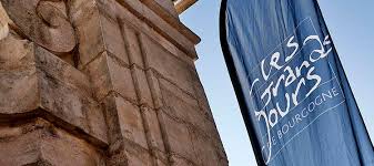 Les Grands Jours de Bourgogne flag in front of a stone building.