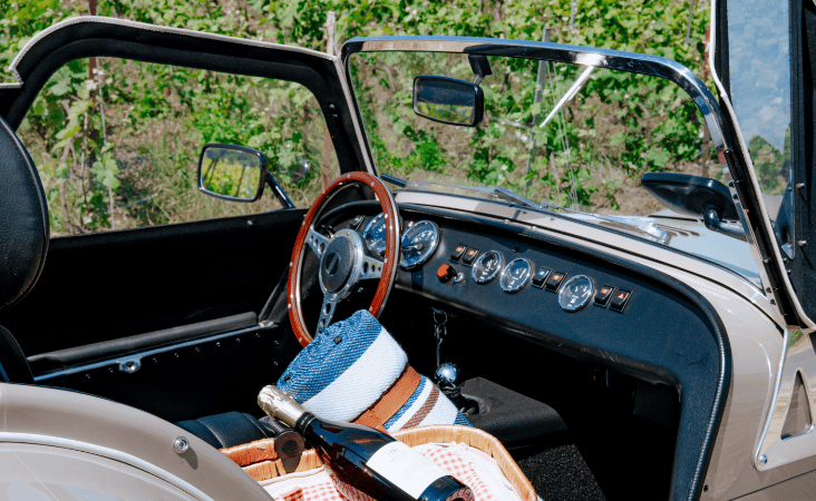 Auto convertibile con cestino da picnic nei vigneti, illustrazione tratta dalla rivista Escales n. 2.