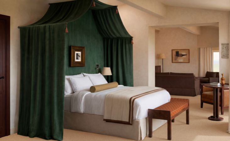 Suite d'albergo di lusso Villa Florentine con letto a baldacchino con tende verde smeraldo e soggiorno adiacente.