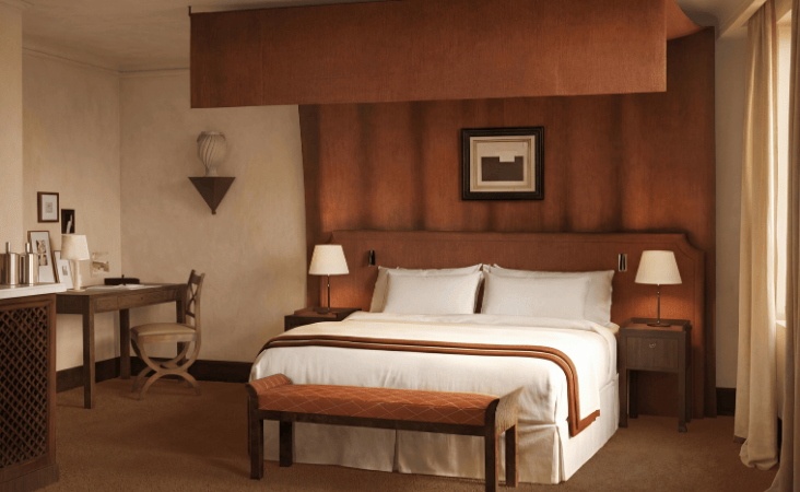 Elegante camera d'albergo di lusso Villa Florentine con letto king-size, testiera in pelle e scrivania.