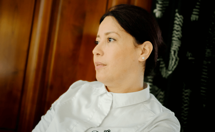 Ritratto dello chef Nawal Rezagui con una giacca da cucina bianca.