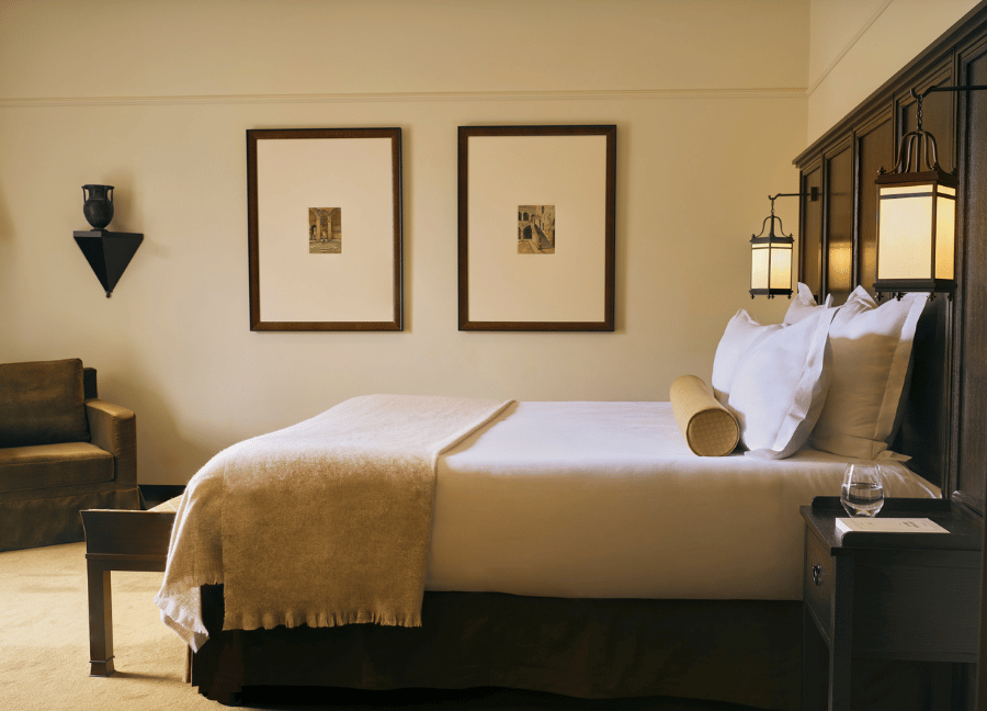 Elegante camera con letto matrimoniale e mobili in legno in un hotel Beauvallon Collection.