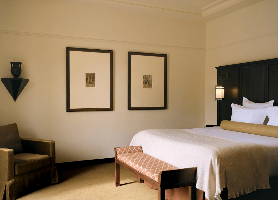 Elegante camera con letto matrimoniale e mobili in legno in un hotel Beauvallon Collection.