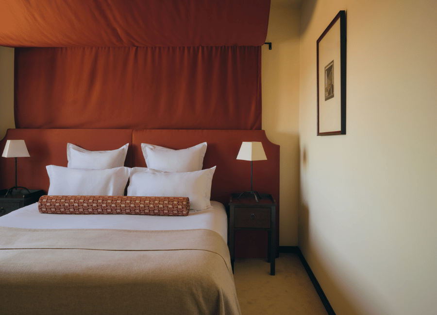 Elegante camera con letto matrimoniale e mobili in legno in un hotel Beauvallon Collection.