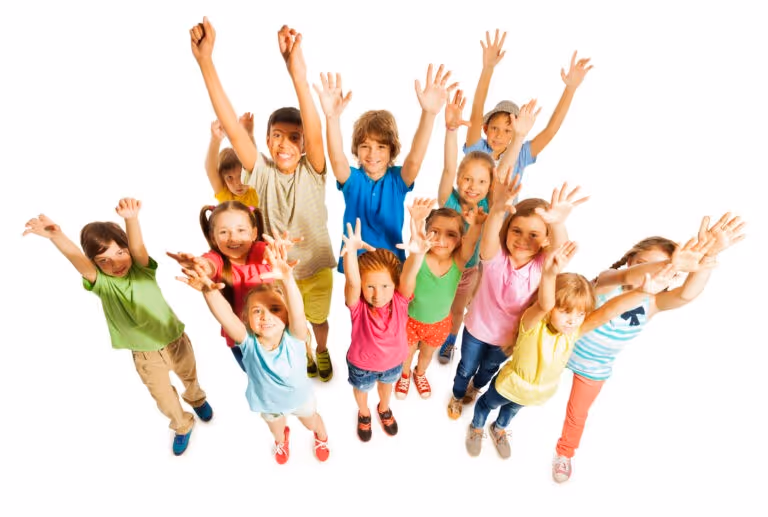 Group of smiling children standing close together with arms raised against a white background.
