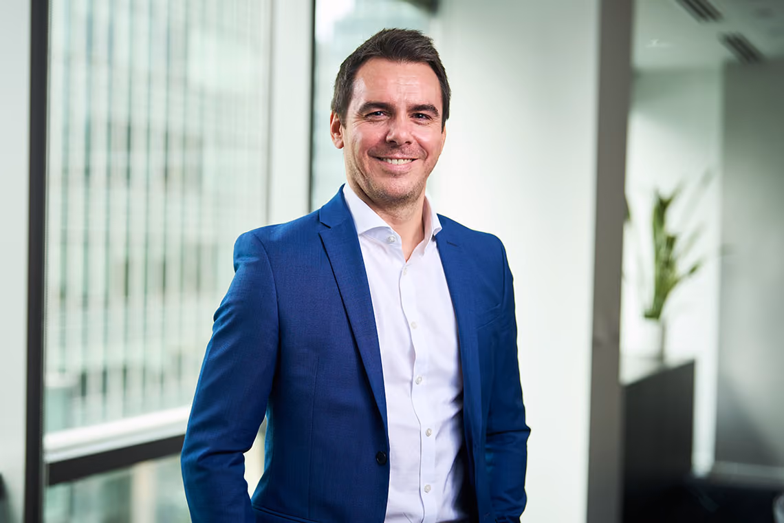 Stephen Britton, Chief Operating Officer at WSD Group, smiling in an office wearing a blue blazer and white shirt