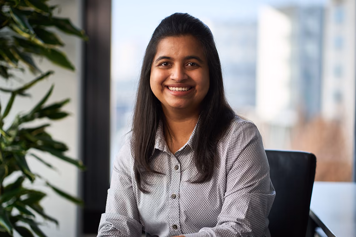 Teshna Rahul, Human Resources Specialist at WSD Group, smiling in an office wearing a patterned shirt