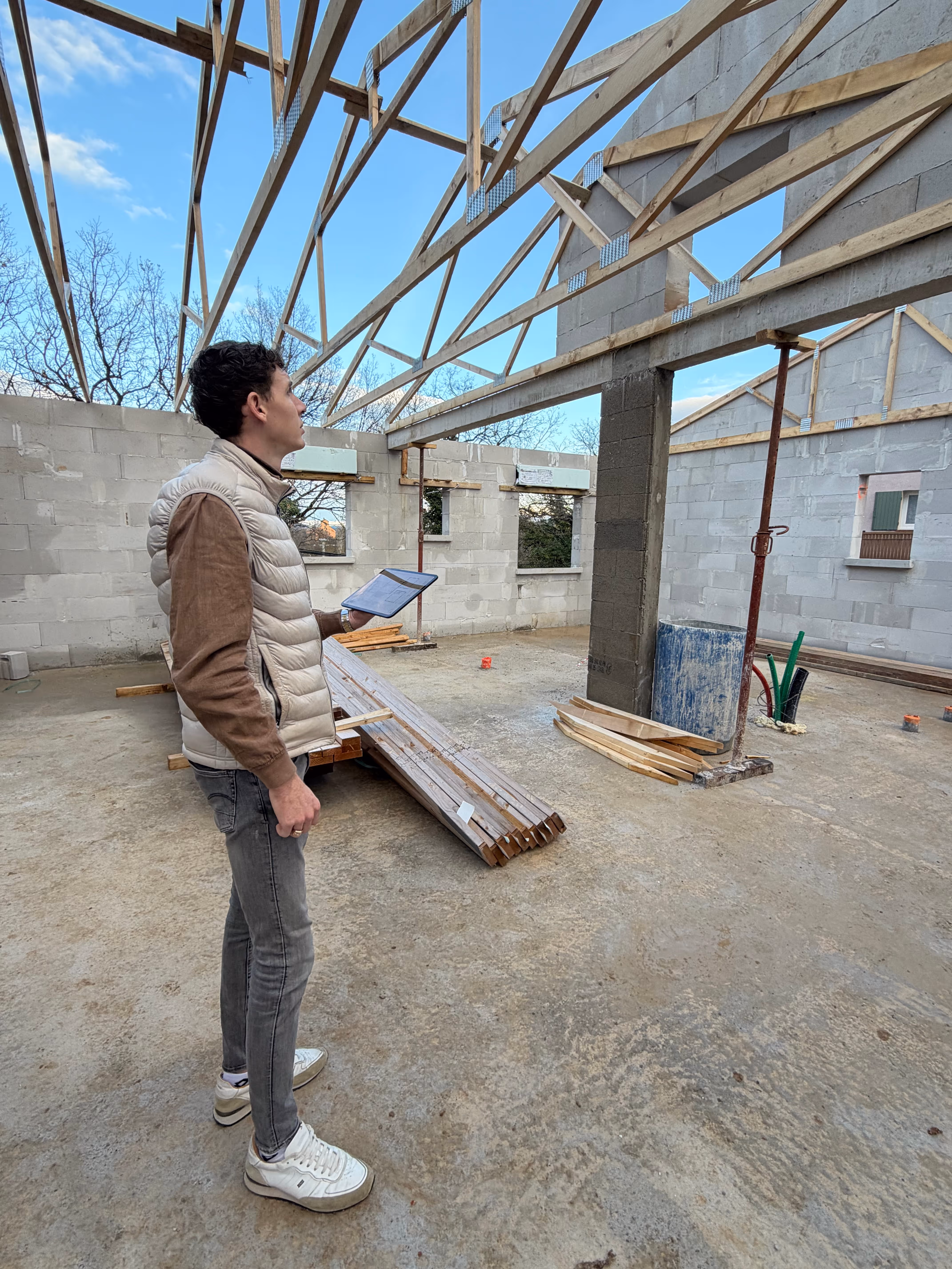 Un couple souriant assis ensemble dans un salon lumineux, partageant un moment de joie.