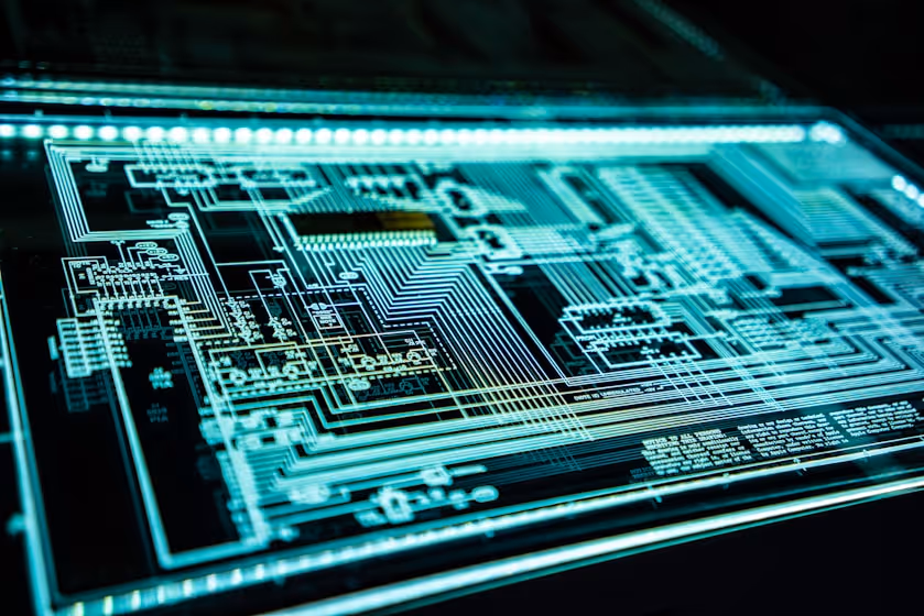 Close-up of a glowing futuristic circuit board with intricate electronic pathways on a dark background.