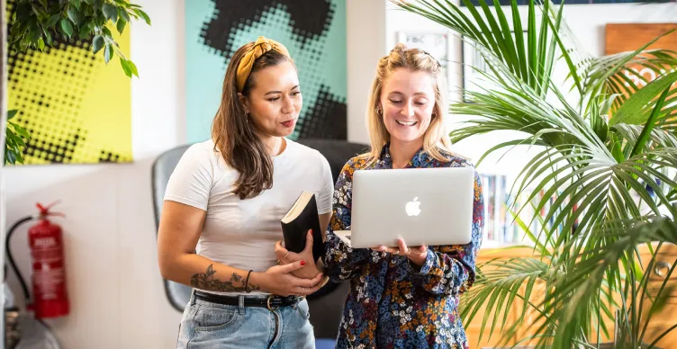 women talking and looking at a laptop