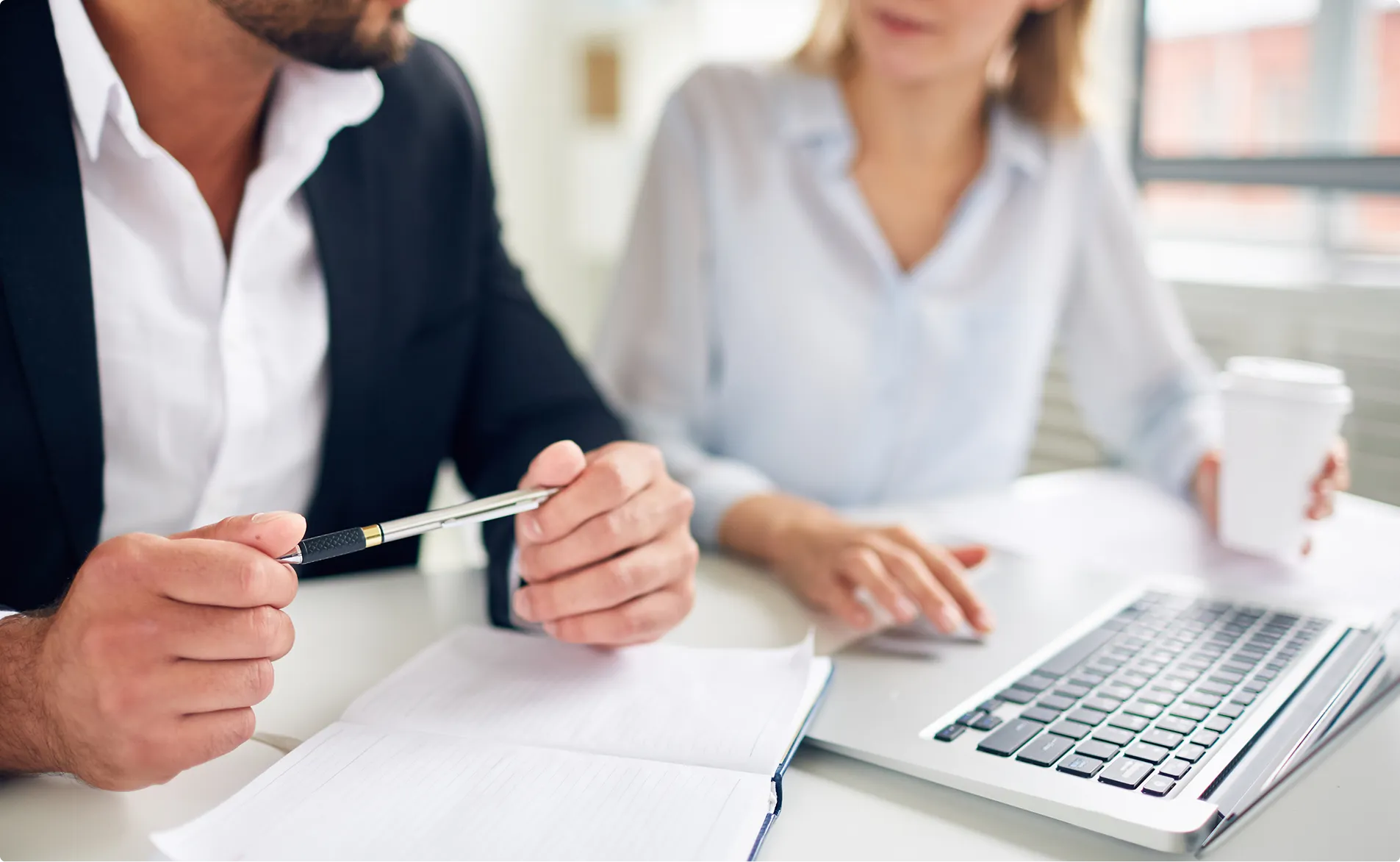 Beratungsgespräch mit Planungsunterlagen und Laptop im Ingenieurbüro