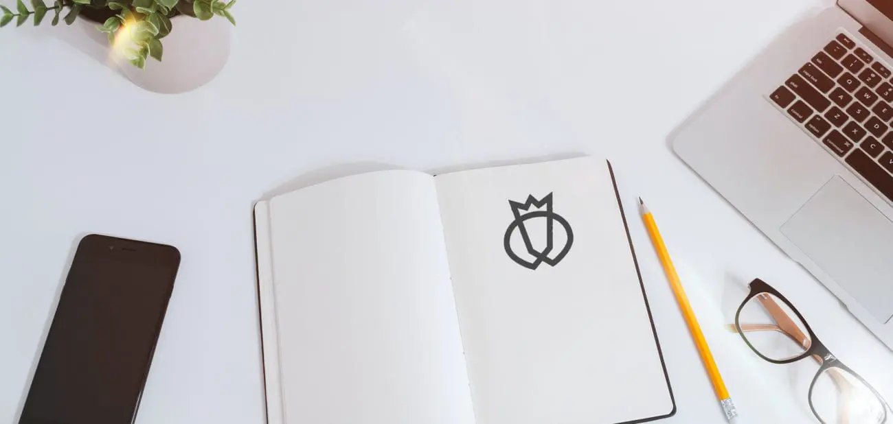 Close-up photo of a desk with a notebook with Testlio's logo