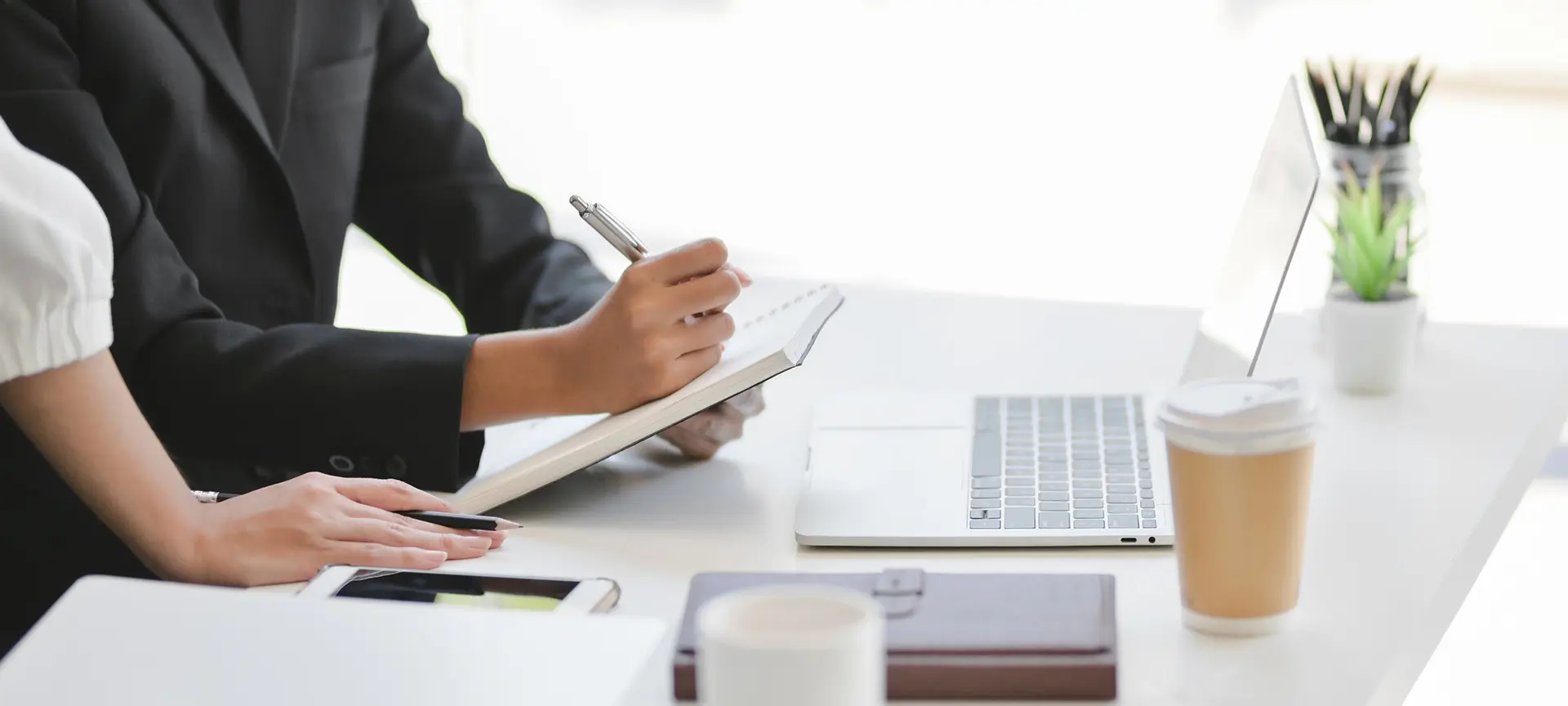 Close-up photo of desktop and people working on the desktop