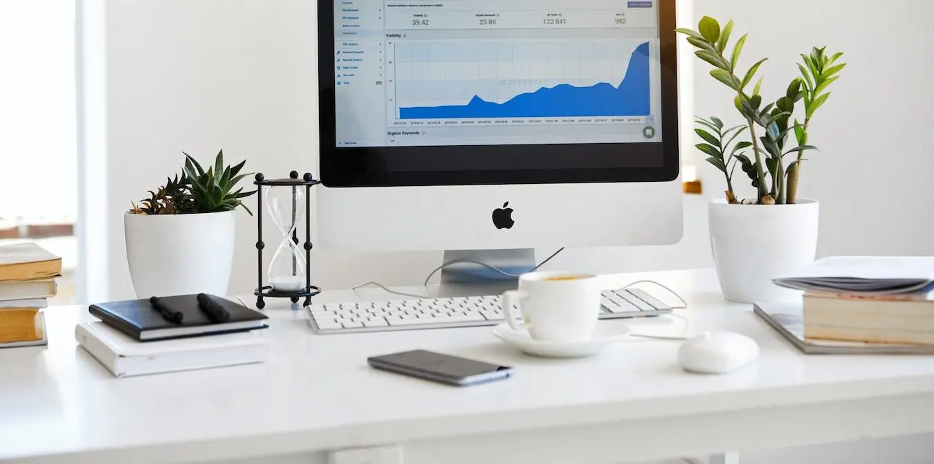 Close-up of a desk with a laptop and notebooks