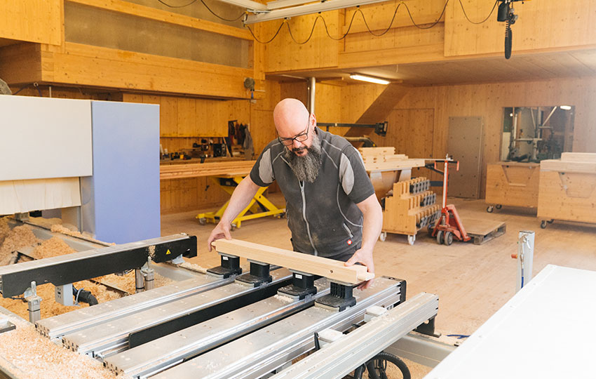 Schreiner bearbeitet ein Holzstück an einer Maschine