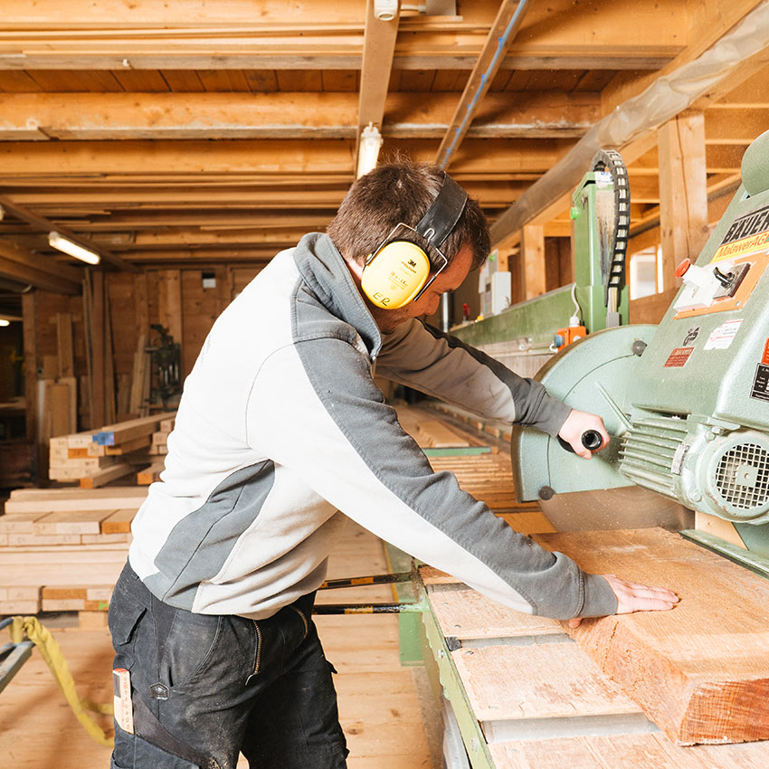Mitarbeiter sägt Holz in der Werkstatt