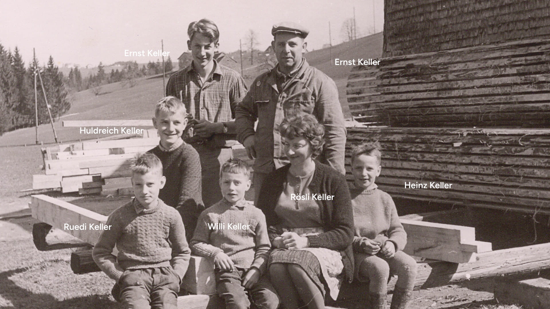Historisches Familienfoto der Familie Keller vor gestapeltem Holz