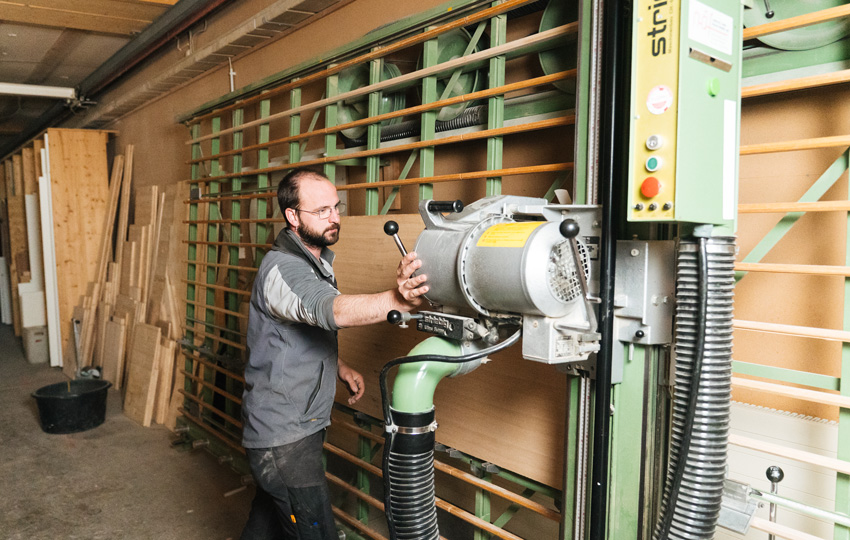 Mitarbeiter bedient Plattenzuschnittmaschine