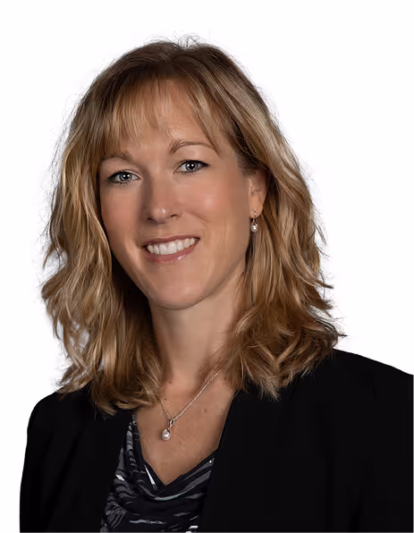 Smiling woman with shoulder-length blonde hair wearing pearl earrings, a pearl necklace, and a black blazer.
