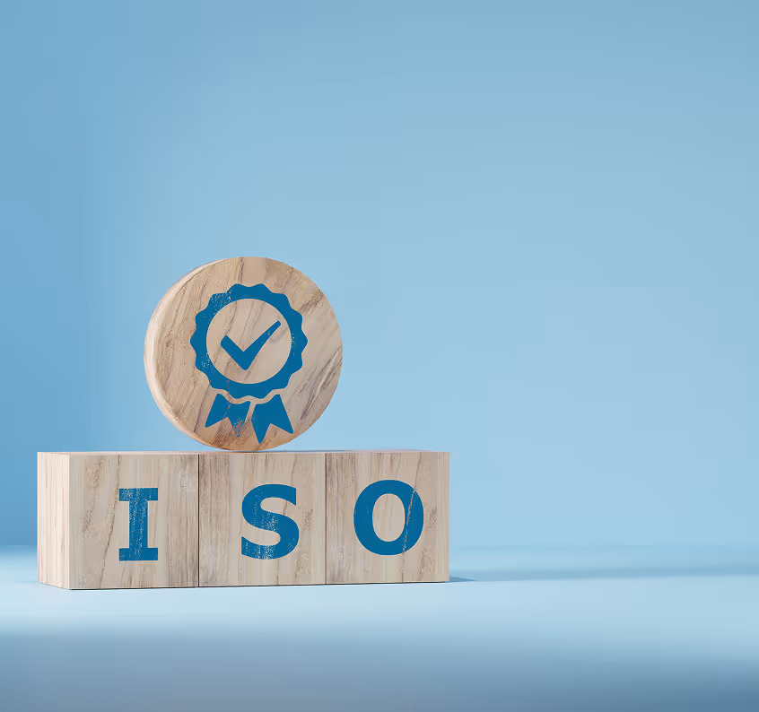 Wooden blocks spelling ISO with a round wooden block on top featuring a blue quality certification ribbon icon.