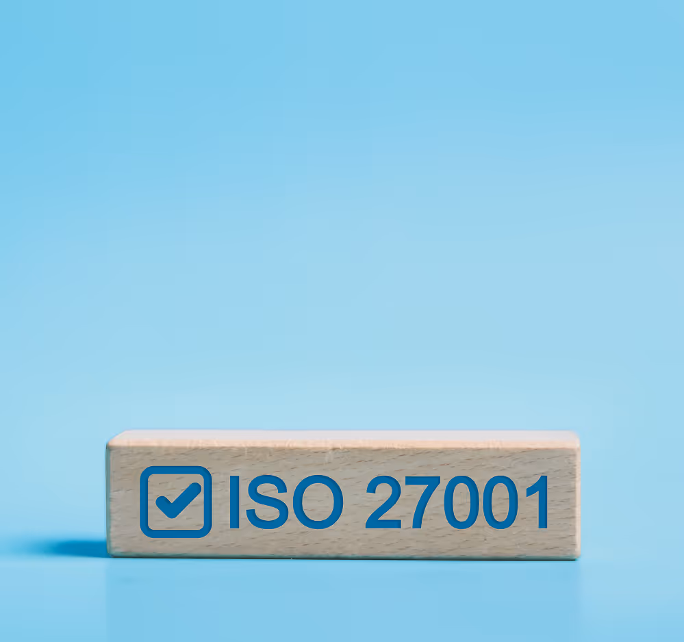 Wooden block with a blue checkmark and the text ISO 27001 on a blue background.