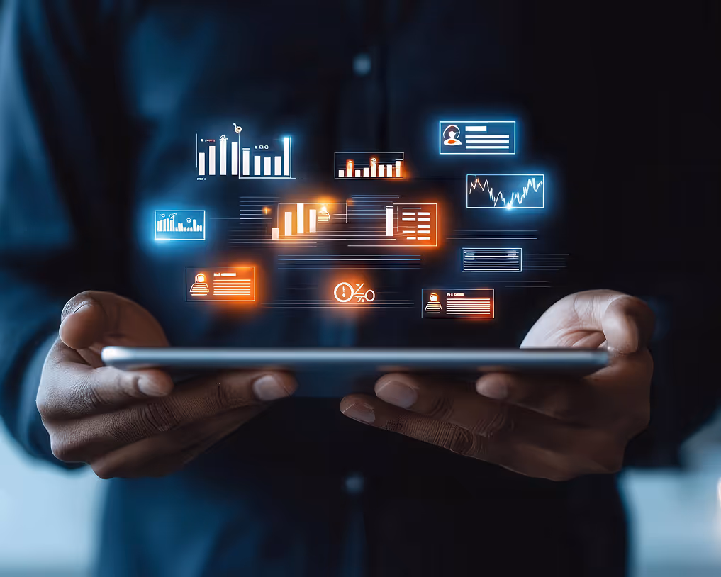 Person holding a tablet with floating digital data visualizations and charts in blue and orange glow.