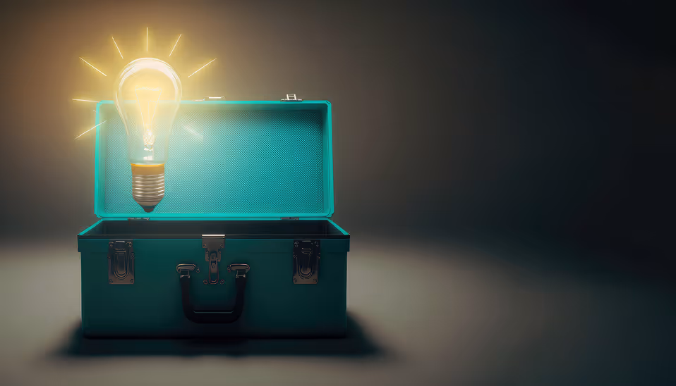 Glowing light bulb floating above an open teal toolbox on a dark background.