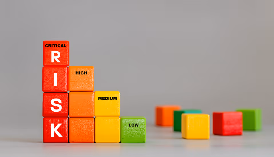 Stacked colored blocks spelling RISK vertically with labels critical, high, medium, and low on descending blocks beside them.