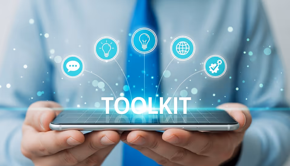 Person holding a smartphone with the word 'TOOLKIT' and five digital icons representing communication, ideas, a light bulb, global connection, and settings floating above the device.
