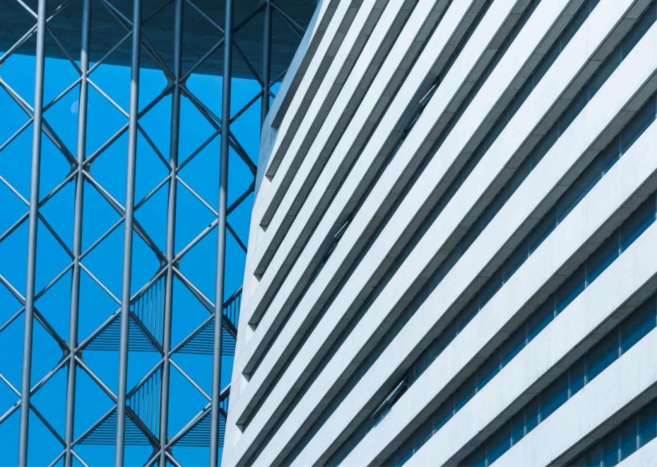 Grayscale image of a modern building with geometric patterns and diagonal lines.