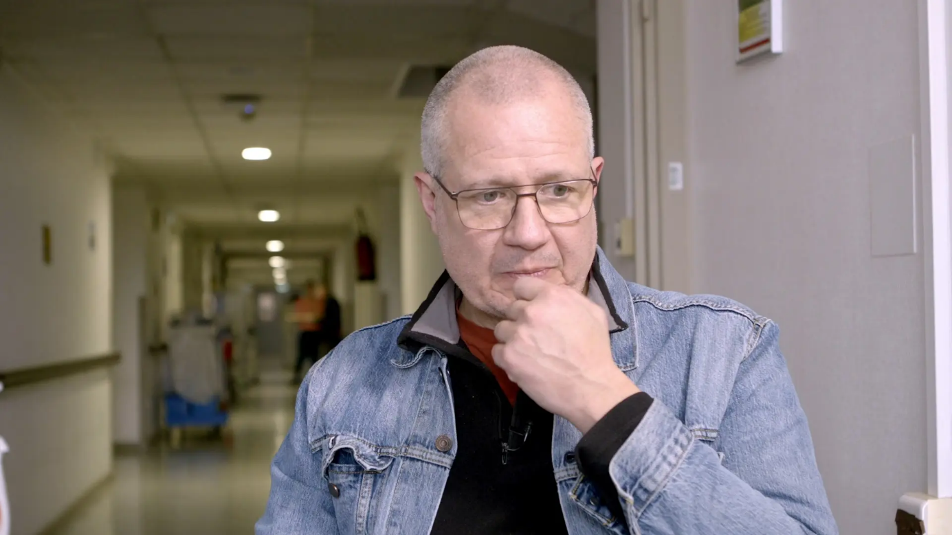 Une image contenant Visage humain, personne, habits, mur