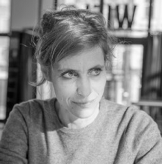 Une photo en noir et blanc montre la réalisatrice Julie Conte. Elle regarde sur la droite de l'image. Elle a les cheveux attachés, le regard est déterminé.