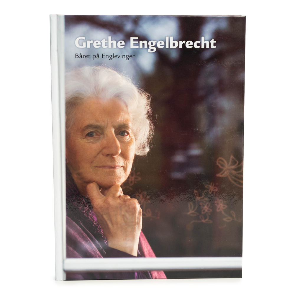 Bog med portræt af ældre kvinde med hvidt hår og hånd under hagen, titel 'Grethe Engelbrecht Båret på Englevinger'.