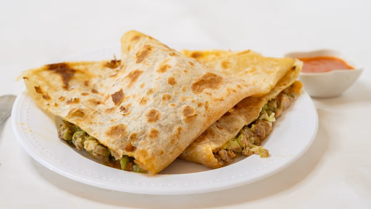 A white plate with a burrito on it.