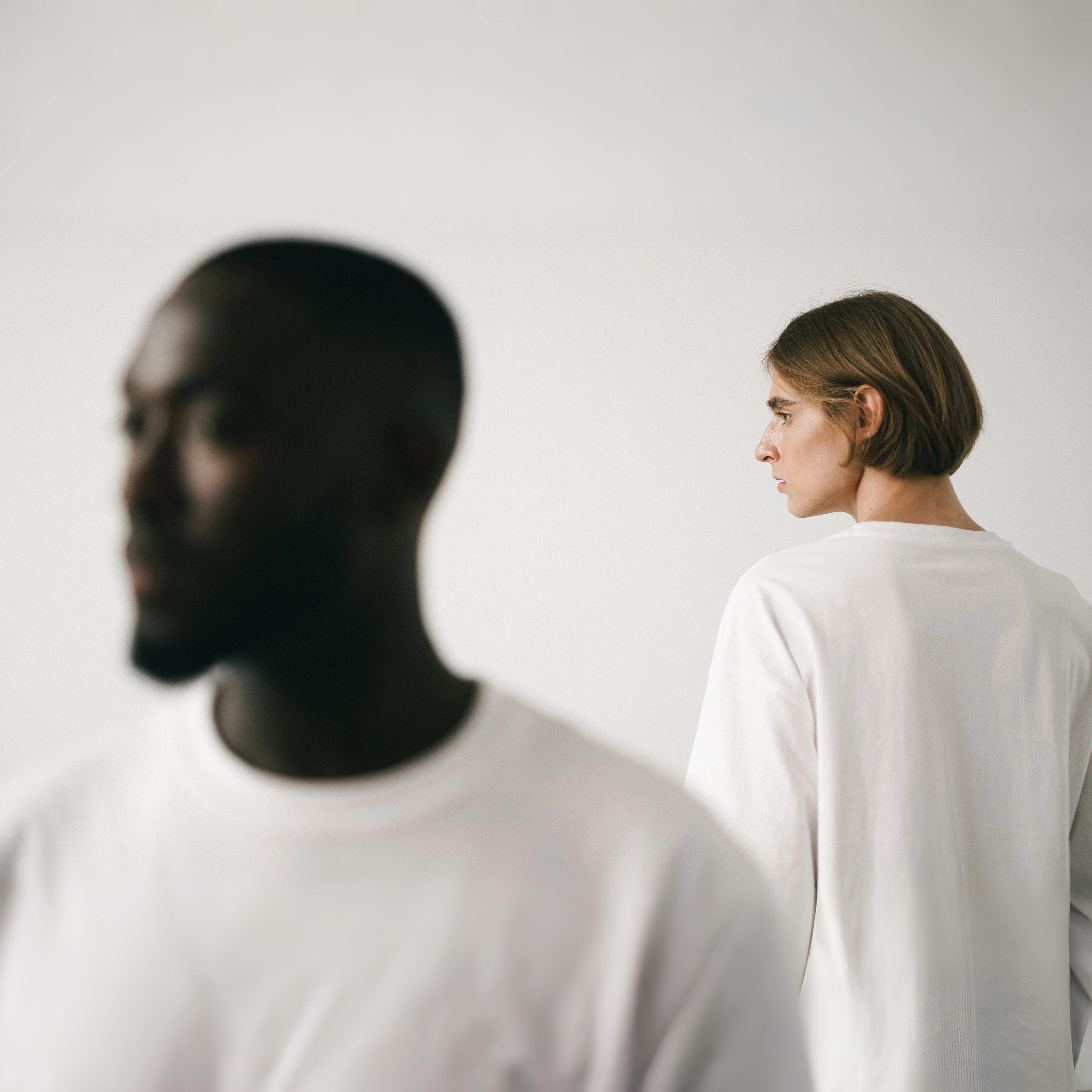 Brunette Man Standing Behind Other Man in Studio