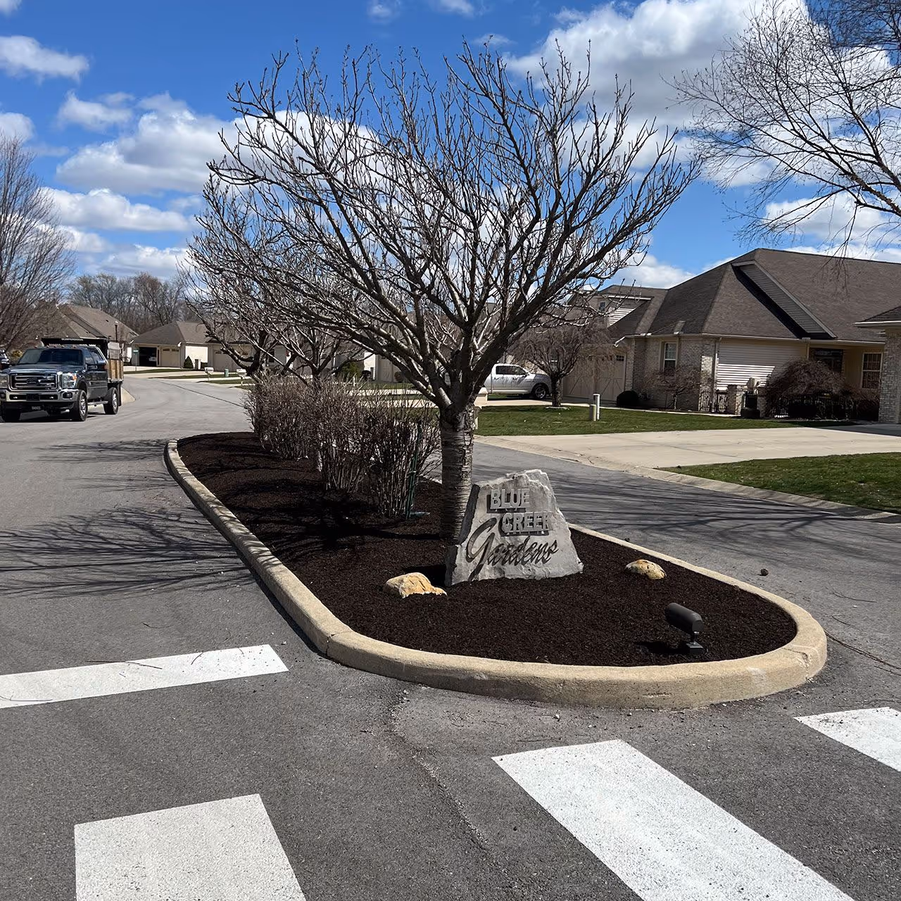 Residential traffic island filled with mulch and rocks by JMS Property Management.