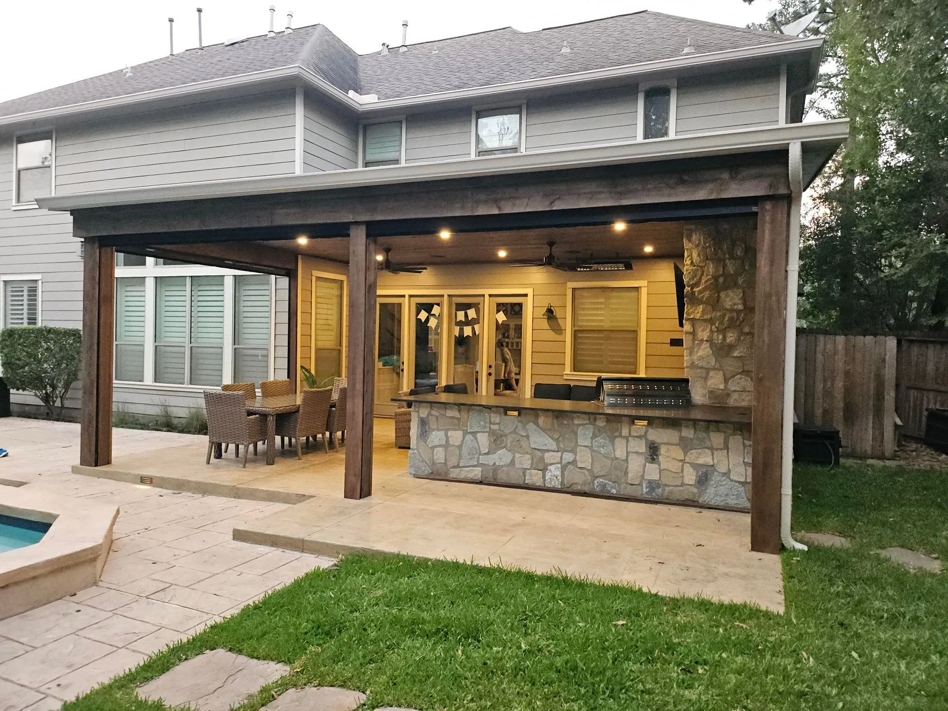 Backyard patio with stone bar and dining area.