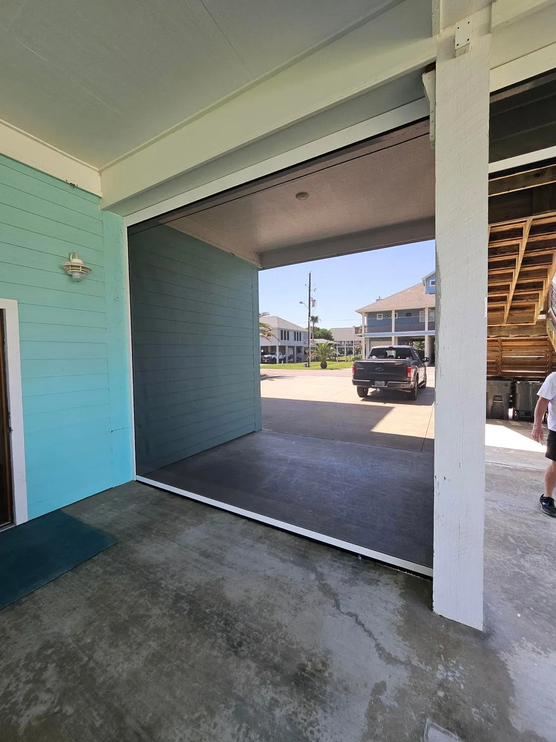 Open garage door revealing a concrete floor and parked truck.