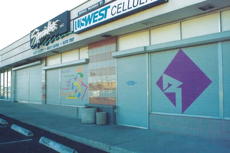 Closed storefronts with painted murals on security shutters.