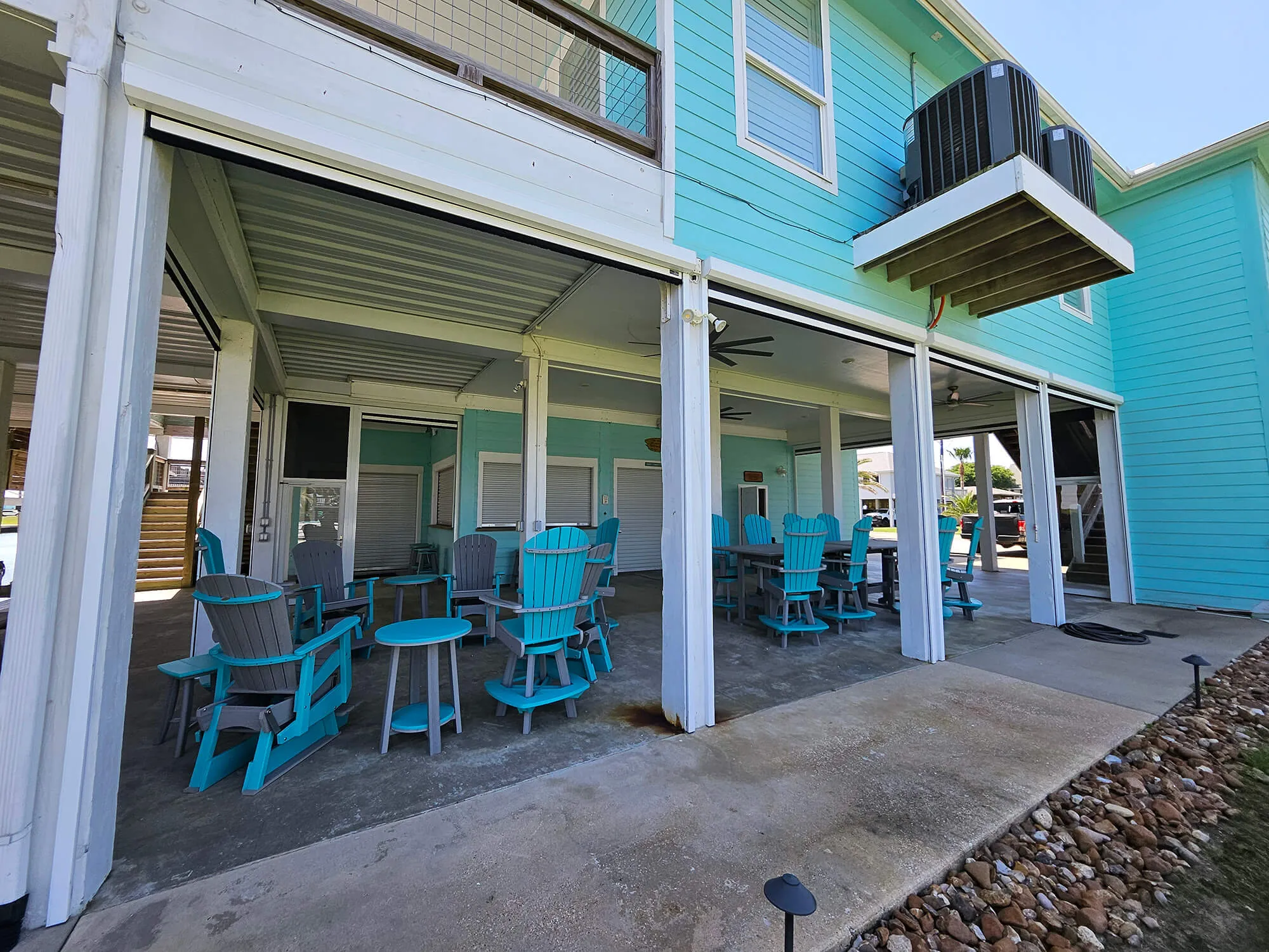 Colorful outdoor seating area with turquoise chairs and tables.