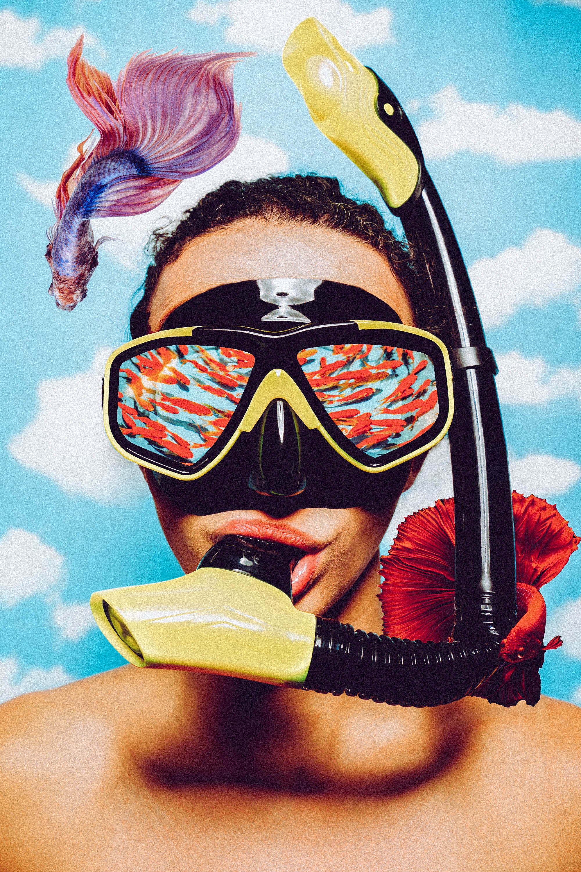 Person wearing a black and yellow snorkel mask with colorful fish reflected in the lenses, holding the snorkel mouthpiece in their mouth, with a red fish attached to the snorkel and a purple fish floating nearby against a blue sky with white clouds background.